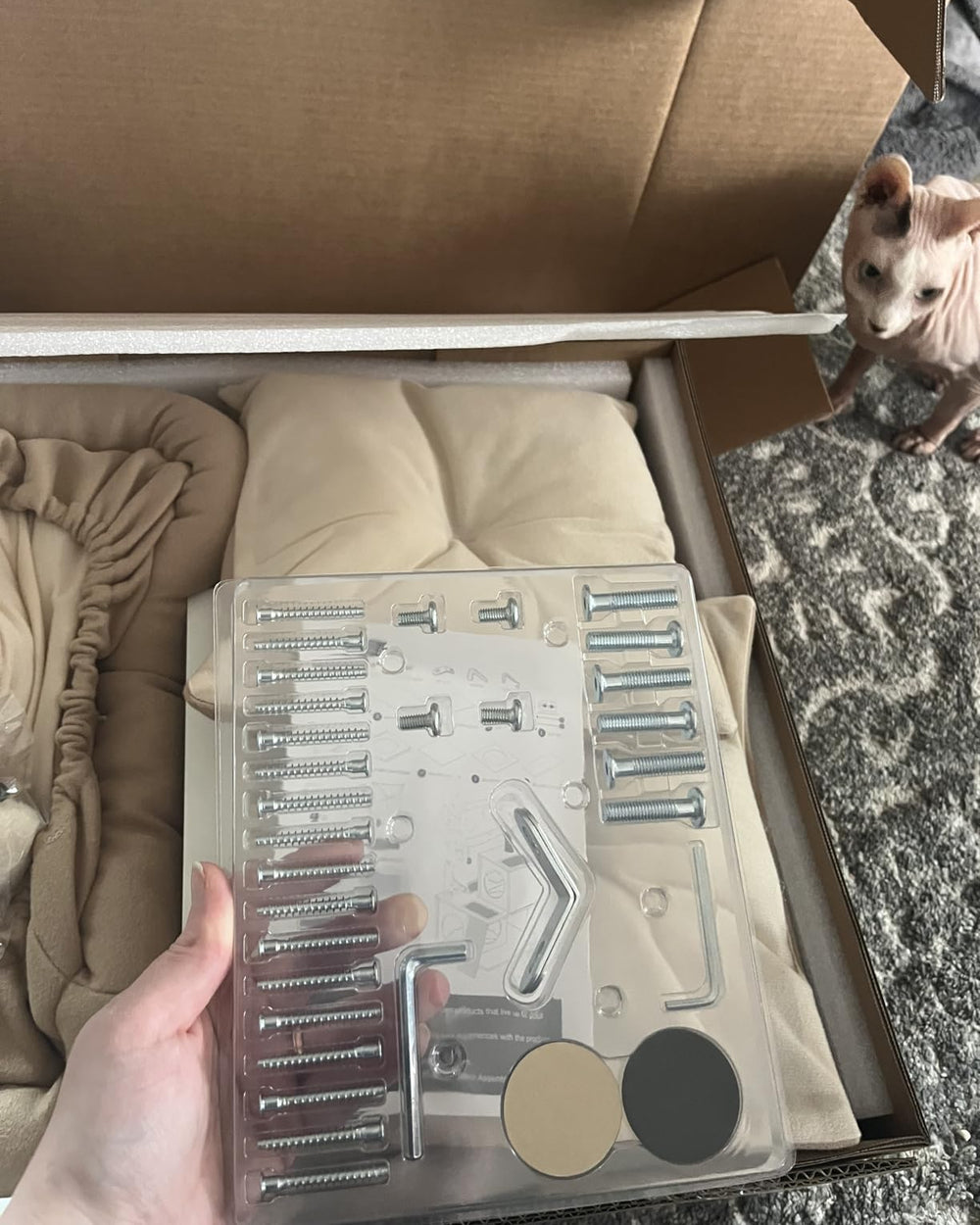 Cat tree unpacking photo showing cushions and assembly hardware