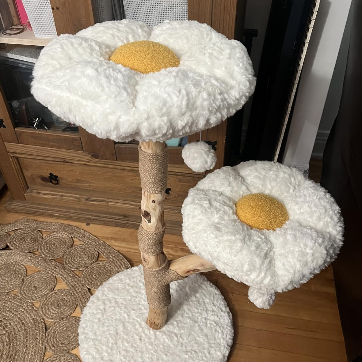 Wooden cat tree with two flower-shaped plush perches in a home