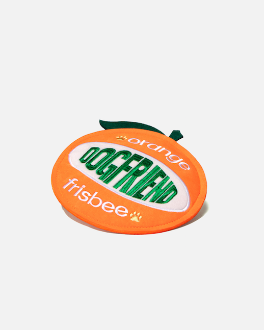 Orange-shaped dog flying disc lying at an angle