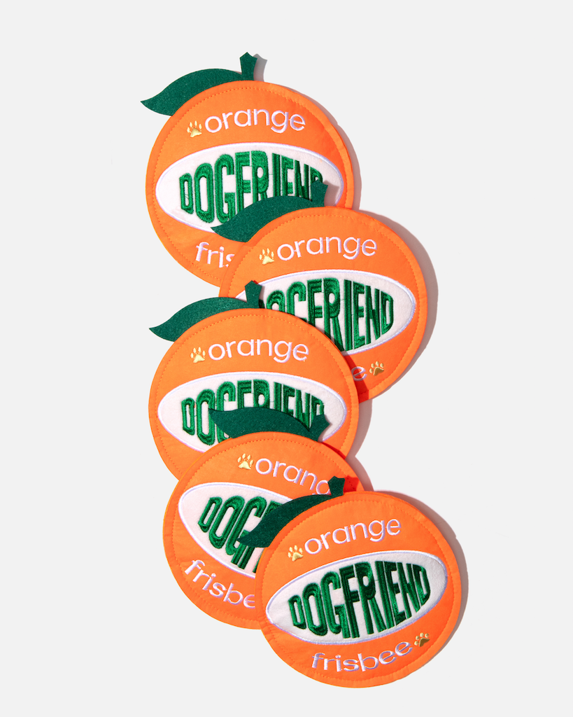 Five orange-shaped dog flying discs arranged in a row