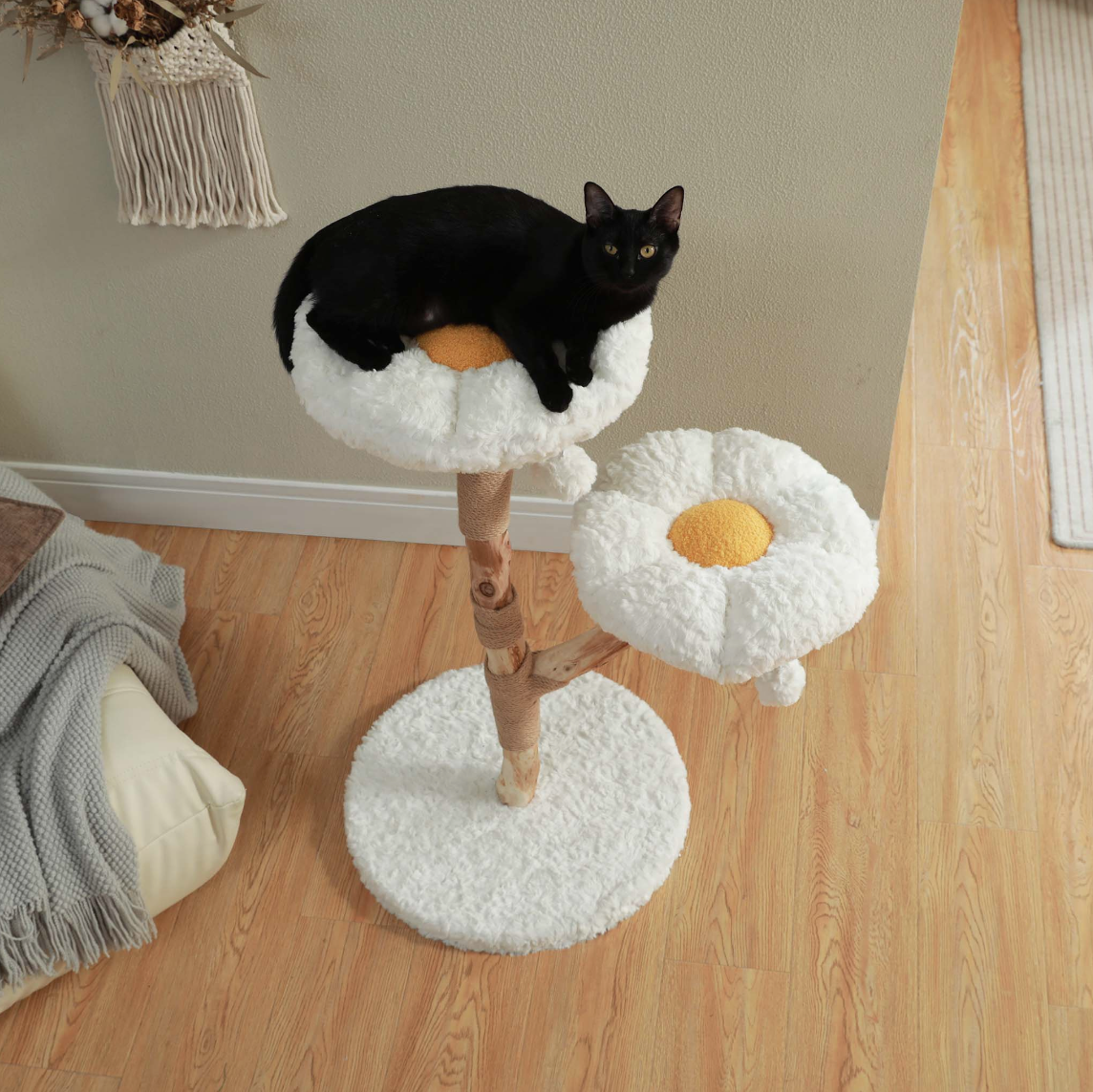 Black cat resting on the upper flower-shaped cat tree perch