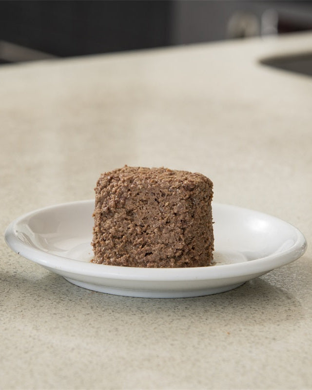 Portion of canned pet food on a white plate