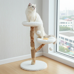 White cat on a flower-perch cat tree beside a window